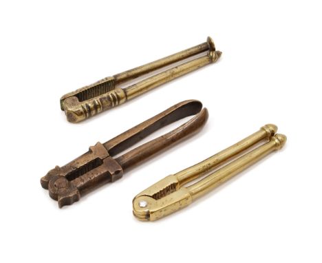 Nutcrackers - an 18th brass lever-action nut cracker, acorn and pipe tamper terminals, 10cm long; others, similar (3) 