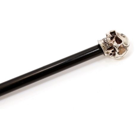 The Macabre - a silver mounted walking stick, the filled pommel as a skull, ebonised cane, 91.5cm long 