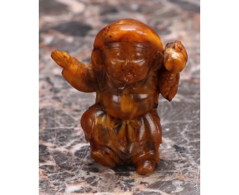 A Japanese amber netsuke, carved as a young boy, 5cm long 