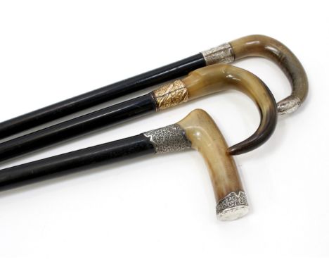 A George V silver mounted walking stick, curved horn handle, ebonised cane, the chased ferrule London 1915; others, similar (