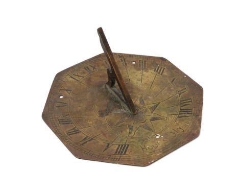 A 19th century brass octagonal sundial, engraved with sun-in-splendour and Roman numerals, and inscribed Hours Fly, 18cm wide