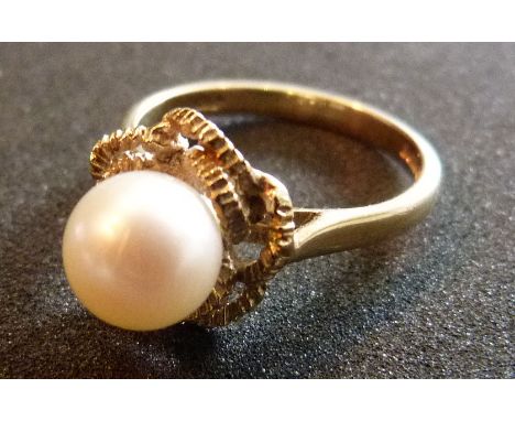 A 9ct gold ring with a single pearl within a pierced setting