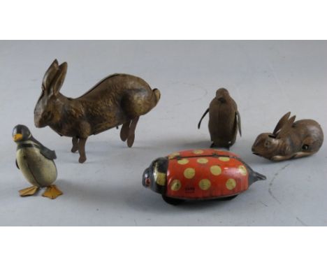 Five tin plate clockwork model animals comprising a hare, rabbit, two penguins and a ladybird, Play worn. Do not know if mech