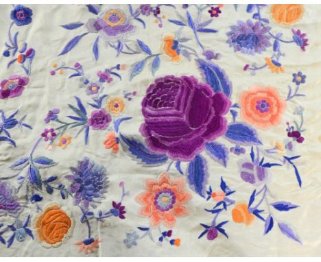 A Shantung silk shawl  embroidered in silk stitch design of floral garlands and sprigs, in purple puce and oranges on a cream