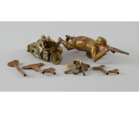 German tin-plate clockwork toy soldier modelled lying on his stomach and firing a rifle, with painted coloured detailing, 19c