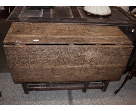 A 17th Century oak gate leg dining table, raised on square section supports united by stretchers, 106cm