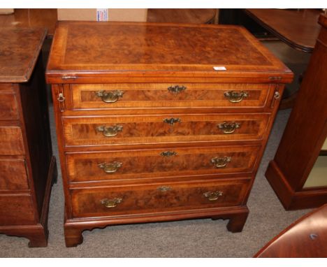 A walnut and herringbone banded bachelor's chest, having foldover top, raised above four long graduated drawers, on bracket f