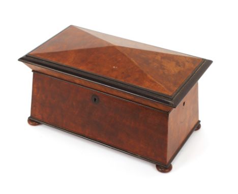 A 19th Century sarcophagus ebony and hardwood tea caddy, with satinwood lined interior, 40cm wide
