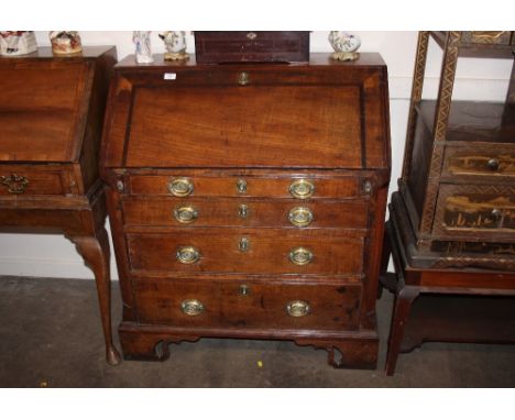 An Antique oak bureau, the fall front opening to reveal an interior arrangement of drawers and pigeon-holes around a central 
