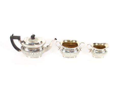 An Edwardian silver three piece bachelor's tea set, of half fluted body design, the teapot with blackwood handle and lift, Bi