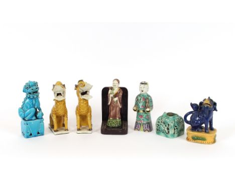 An Antique Chinese turquoise glazed pottery figure of a Kylin; another famille rose decorated example of a man carrying a scr