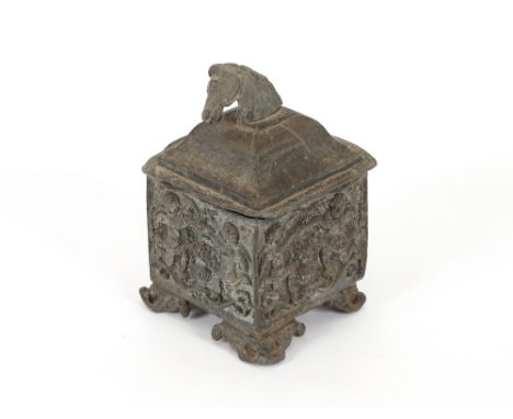 An Antique lead tea caddy, the lid with horse's head handle, the body with raised figural and foliate decoration, 19cm high
