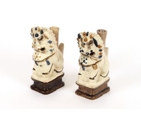 A pair of 19th Century Chinese pottery temple dog joss stick holders, decorated in white slip ochre and dark blue, 15cm high