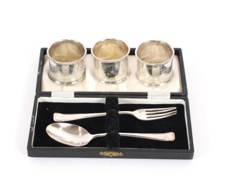 A cased silver fork and spoon, Birmingham 1961; three silver plated napkin rings; a silver tea strainer; six silver bean top 