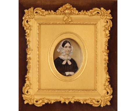 A Victorian portrait miniature of a lady, wearing black dress and lace bonnet, contained in a foliate decorated gilt frame an