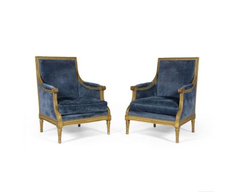 Paire de bergères à dossier plat en bois redoré de la première partie du XIXe siècleA décor sculpté de frises de piastres, de