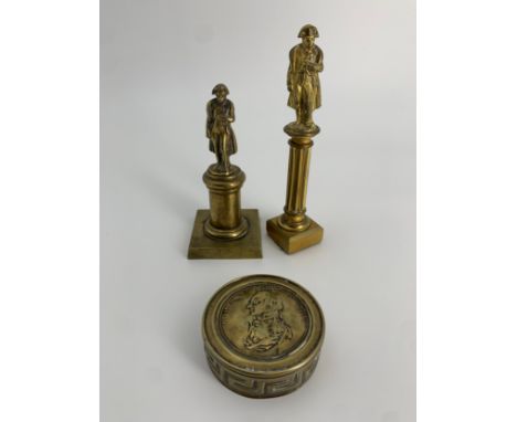An early 19th century brass snuff box commemorating Admiral Lord Nelson along with two brass Napoleon figures mounted on colu