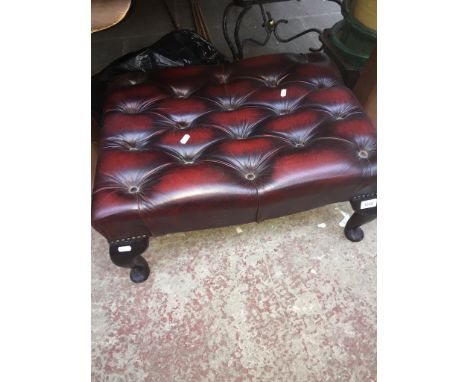 An oxblood buttoned leather pouffe 