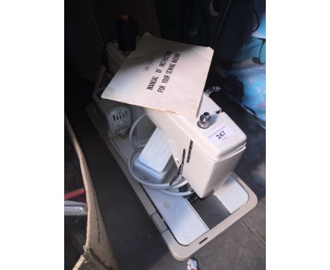 A New Home electric sewing machine complete with pedal, manual and case. 