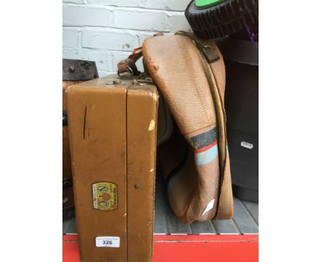 A vintage leather suitcase with shipping labels and a small suitcase 