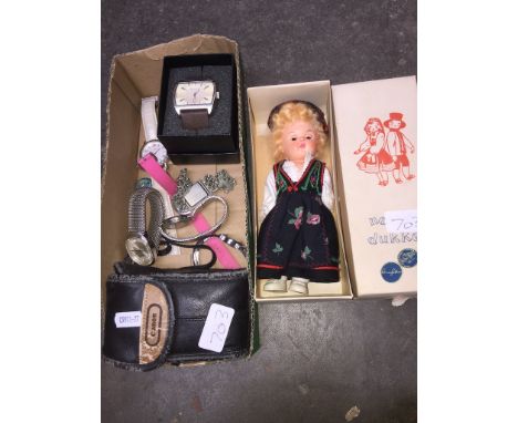A box of watches. a Norske Dukker doll and a Canon sure shot classic 120 camera