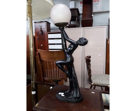 An Art Deco plaster table lamp modelled as a semi nude dancing girl holding a spherical shade. 