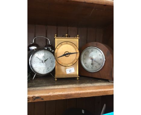 An alarm clock, a mantel clock and a brass quartz clock. 