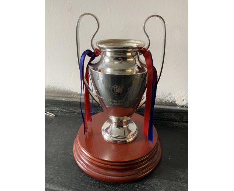 Champions League Replica Trophy: Small trophy with what could be Barcelona ribbons attached. Wooden plinth that it sits on co