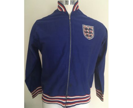 Bobby Moore England Football Tracksuit Top: Umbro top in blue with red and white trim to neck and cuffs. England stitched to 