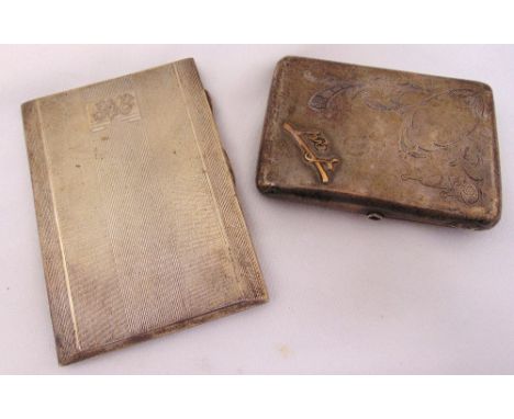 A Russian white metal cigarette case with hinged covers and cabochon set thumb piece and a hallmarked engine turned cigarette
