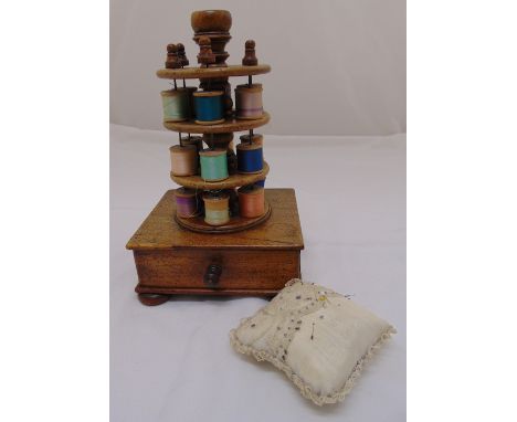 A Victorian wooden sewing caddy of three tier circular form on rectangular base with single on four bun feet and a pin cushio