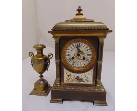 A brass mantle clock with enamel dial and Roman numerals and a single vase form garniture, 38cm (h)