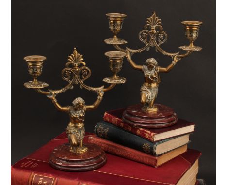 A pair of 19th century bronze two-light figural candelabra, each cast in the Orientalist taste as a kneeling Nubian girl, rou