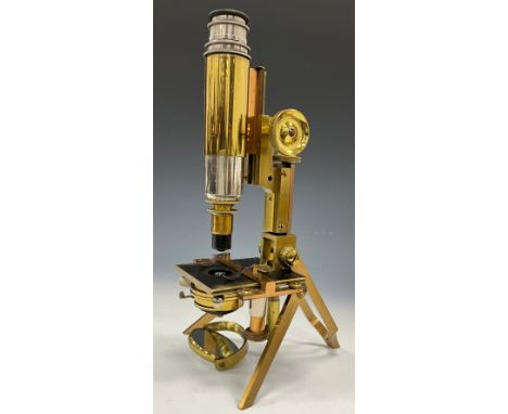 An early 20th Century brass monocular microscope by J Swift and Son London No 624, single lens on folding legs and stand, 27.