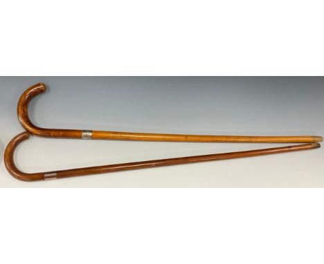 A George V walking stick, the silver collar stamped Brigg, curved handle, malacca cane, 93cm long; another similar (2)