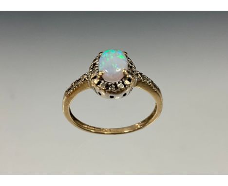 An opal and diamond ring, oval cabochon opal flashing green, blue and orange play, with diamond accented mount, 9ct gold shan