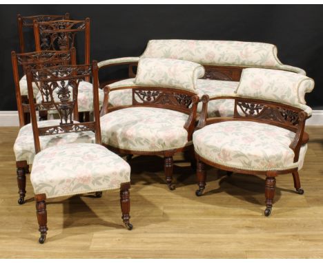 A late Victorian/Edwardian walnut and mahogany seven-piece salon suite, comprising sofa, a pair of club chairs, a pair of sid