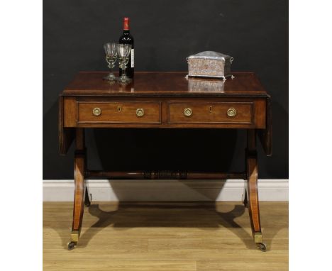 A Post-Regency tulipwood crossbanded mahogany sofa table, rounded rectangular top with channelled edge and fall leaves above 