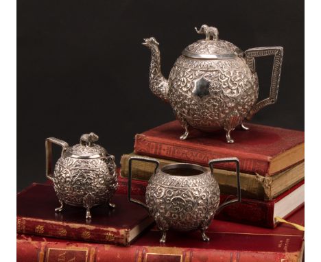 An Indian silver three-piece bachelor's tea service, comprising teapot, milk jug and sugar basin, profusely chased in the Kut