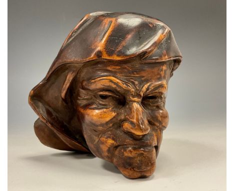 A Continental walnut boss or corbel, carved as a grimacing man, 11cm long, 18th/19th century