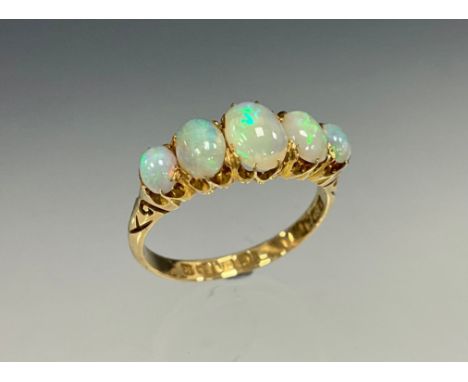 An Edwardian five stone graduated opal cabochon ring, flashing vibrant green, violet and red colour play, 18ct gold shank, si