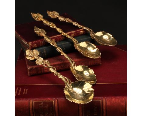 A set of four George III silver-gilt serving spoons, cast throughout with fruiting vine, 20cm long, possibly Robert Garrard, 