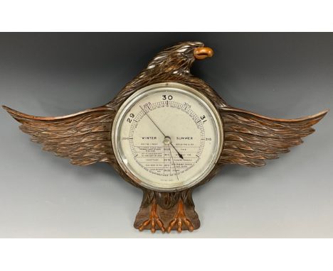 A George V barometer, the case carved as an eagle with wings displayed and lowered, silver coloured dial, 32cm high, 53cm wid