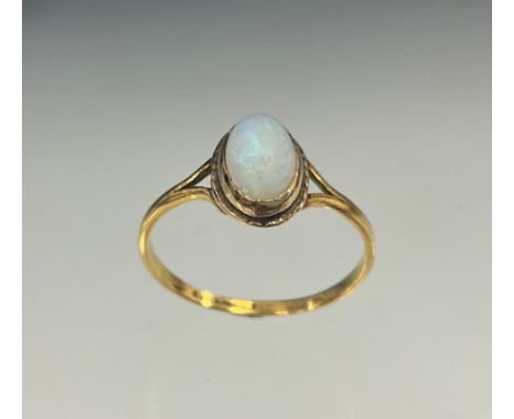 A Victorian opal cabochon solitaire ring, oval violet, green and orange opal cabochon, approx 9mm x 6mm, 22ct gold shank, siz