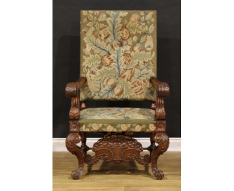 A substantial French Baroque walnut armchair, the bold scroll arms and cabriole legs carved with acanthus scrolls, shaped str