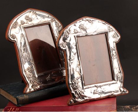 A pair of Art Nouveau period silver easel photograph frames, embossed in the Aesthetic Movement taste with songbirds amongst 