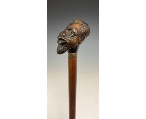 A Victorian figural walking stick, the pommel carved as a man of African descent, glass eyes, silver plated collar, oak cane,
