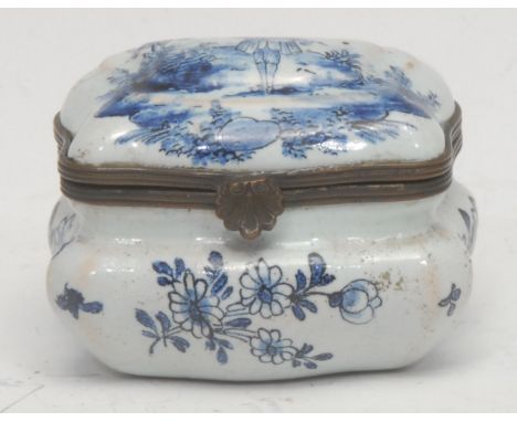 A 19th century Delftware enamel snuff box, the hinged cover mounted with a young man plucking a fiddle, the sides decorated w