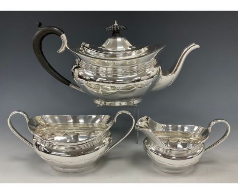 A George VI silver three piece tea set, teapot with ebonised scrolling handle, twin handled sugar bowl and milk jug, Israel F