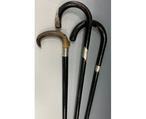An early 20th century walking stick, curved horn handle, silver metal collar engraved with foliate scrolls, ebonised cane, 89